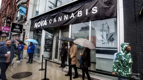 Toronto Star via Getty Images People line up for the opening of a legal cannabis store in Toronto