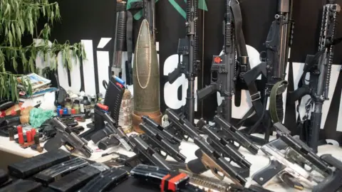 Getty Images Police show the weapons they say were seized during the operation