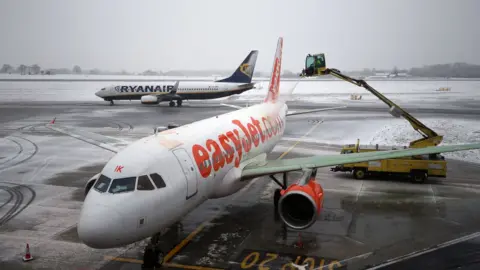 PA An easyJet plane is de-iced at Luton Airport