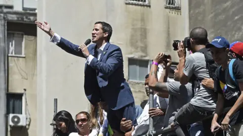 AFP Venezuelan opposition leader and self declared acting president Juan Guaido speaks during a rally to press the military to let in US humanitarian aid, in eastern Caracas on February 12, 2019.