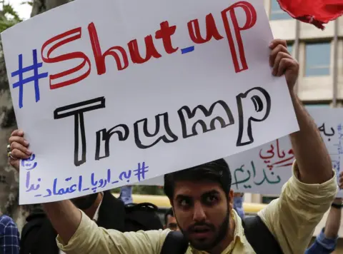 AFP Iranian man holds up a banner saying: #Shut_up Trump" at a protest outside the former US embassy in Tehran on 9 May 2018