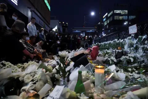 Reuters People pay their respects near the scene of a crowd crush that happened during Halloween festivities, in Seoul, South Korea, October 31, 2022.