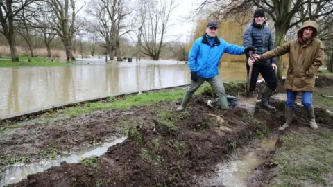 South Beds News Agency Gary Huntley, Franco Felice and Adrian Coleman, who dug a trench alongside the river