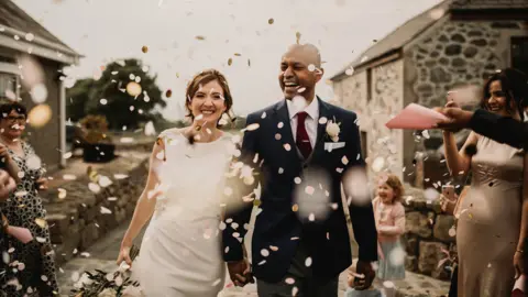 Love Luella Photography A picture of a wedding couple with confetti falling in front of them