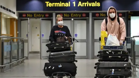 Getty Images Couple reaching arrivals at a UK airport