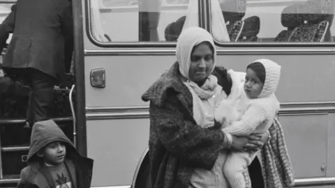 Getty Images Refugees were transported by coach from Stansted Airport to the resettlement camp