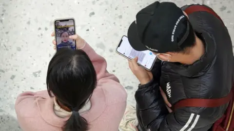 Getty Images iPhone users at a shopping mall in China.