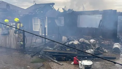 Bungalow fire being extinguished by fire crews