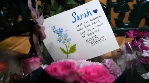 PA Flowers laid and a card laid at a vigil marking five years since the death of Sarah Everard, at Clapham Common Bandstand