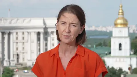 Sarah Rainsford in an orange shirt.