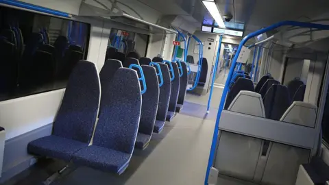 Getty Images A row of dark blue seats on a train.