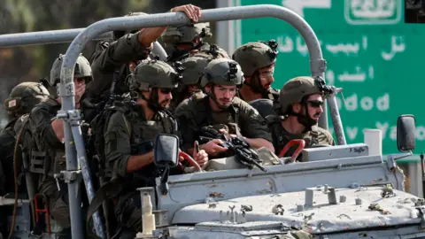 Reuters Israeli troops lead in a Jeep in southern Israel during Hamas attack on October 7, 2023 against Israel 