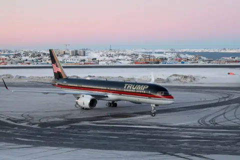 Getty Images Pesawat Donald Trump Jr, bertuliskan 'Trump' di bagian depan, di bandara Nuuk Greenland. Es dapat dilihat di landasan dan pemandangan bersalju di belakang.