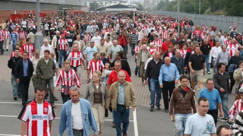 Duncan Holley crowds of fans walking away from the stadium 