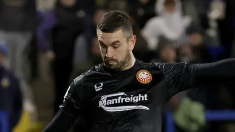 Aaron Hogg in black football top, he has short brown hair