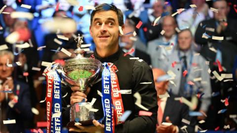 Ronnie O'Sullivan holding the World Snooker Championship trophy