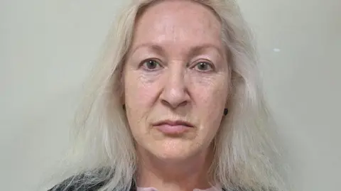 Hertfordshire Constabulary A custody photo of a woman with long grey hair.