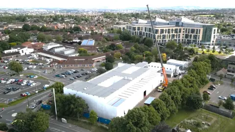 An aerial view of the surgery centre at Southmead, with white building surrounded by cars and trees.