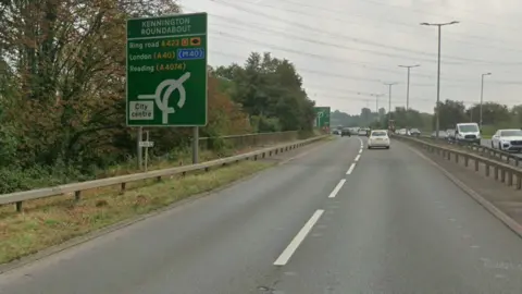 A view of the Southern By-pass Road on an overcast day. There are cars travelling in each side of the dual carriageway.