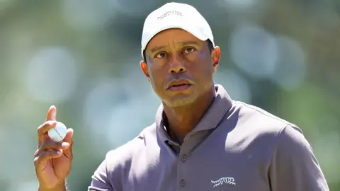 Tiger Woods holds the ball and stares ahead after a putt during the 2024 Masters 