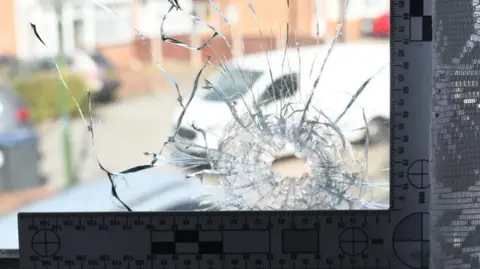West Midlands Police A bullet hole in a window