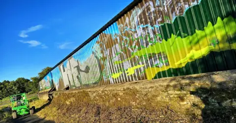 Murals by Sarah A barn building covered with graffiti and scrawls of paint