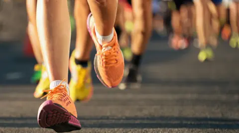 Getty Images An image showing runners' legs in a race.
