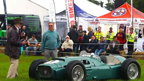 Chris Davies Image of two men near a green vintage car at the Bath Rotary Festival of Motoring
