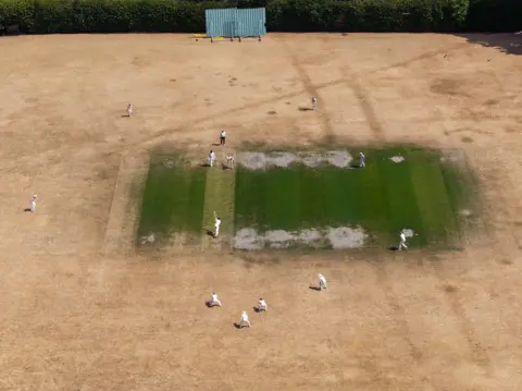 Getty Images In this aerial view the Maidenhead & Bray CC 1st XI take on the Boyne Hill CC 1st XI on a bone dry field at the Maidenhead & Bray County Cricket club on July 25, 2026 in Bray, United Kingdom.