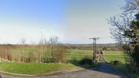 A picture taken from Hexham Road of the fields where the burial ground could be built. The fields are used for farming and a private road runs alongside them.