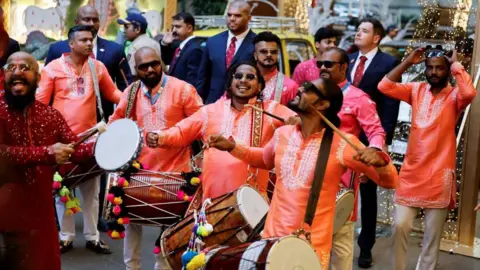 Reuters A band plays drums during the pre-wedding ceremony of Anant Ambani and Radhika Merchant outside the residence of Mukesh Ambani, in Mumbai, India, July 3, 2024.