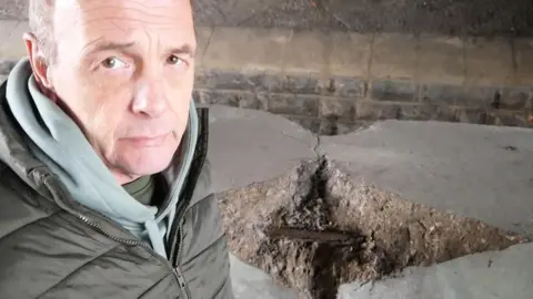 David Henwood taking a selfie in front of a large chunk of the missing bridge.