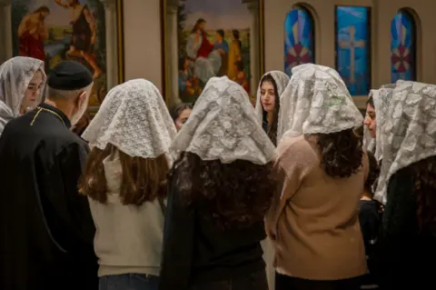 Members of the Syrian orthodox congregation singing hymns at a memorial service in Orebro.