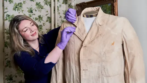 National Trust/PA Wire Curator Katherine Carter with former prime minister Winston Churchill's painting coat.