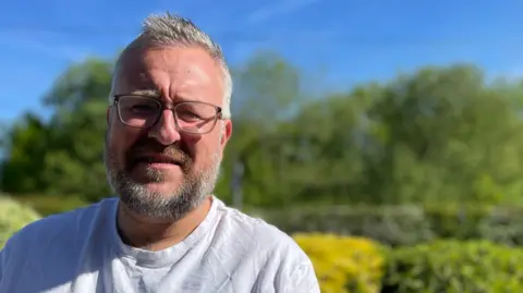 A man in spectacles stood outside