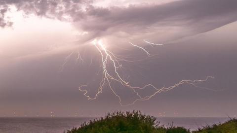 Lightning strikes in sky on coastline of Frinton-on-Sea