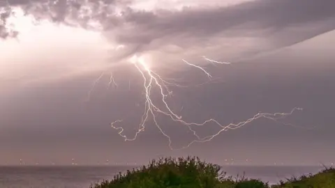 Lightning strikes in sky on coastline of Frinton-on-Sea