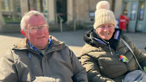 a man and a woman sitting on a bench