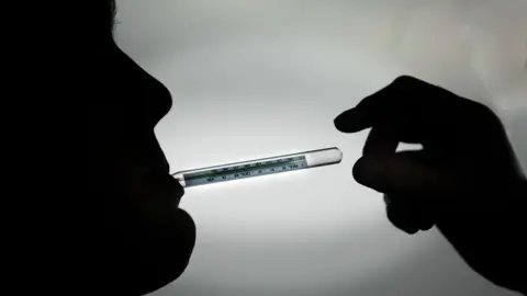 PA Media Thermometer in mouth of a patient (in silhouette).