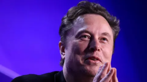 Reuters Close up of Tesla chief executive Elon Musk against a blue background