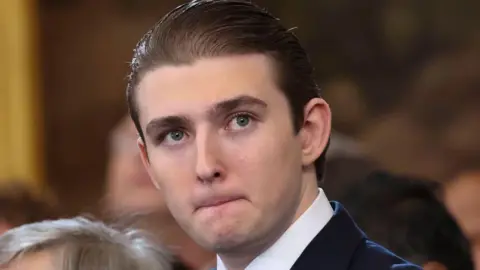 Baron Trump is pictured at his fathers inauguration in the Rotunda of the U.S. Capitol on January 20, 2025. His hair is slicked back. 