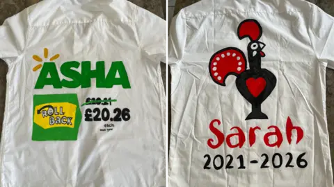 Joy Nzau Two white shirts have hand painted designs on them. On the left, a shirt says 'Asha' and on the right in the Nando's logo it says Sarah
