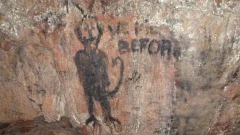 George Nash A side chamber in the cave showing historic graffiti over possible prehistoric imagery