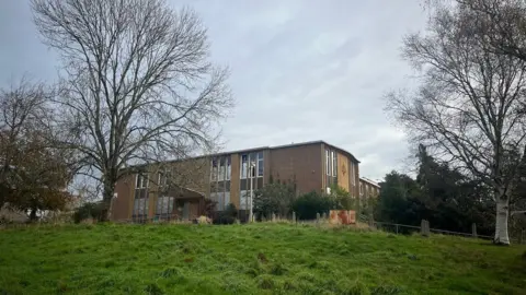 The former magistrates' court on Heavitree Road with autumnal trees around the site.