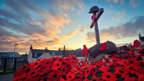 Michael Diamond The poppy display during sunset with a photo of the cross