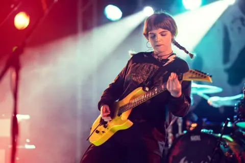 Dr David Gange Female musician Debbie Gough, frontwoman of Heriot, plays a yellow guitar