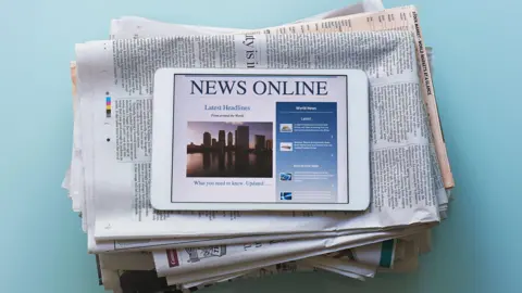 Getty Images A stack of papers with a tablet on top 