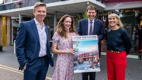 Salisbury Playhouse Gareth Machin, Emilia Williams, Salisbury MP John Glen and Rosa Corbishley stand together in front of the Salisbury Playhouse with a poster showing what the newly redeveloped site may look like.