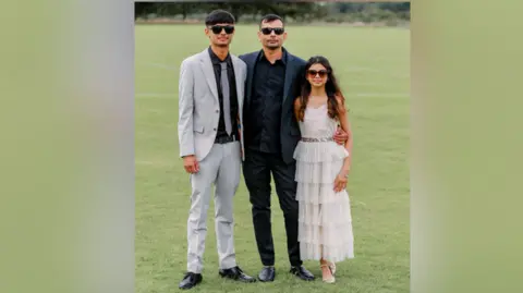 Family handout Vyom, Ketan & Yahvi Shah pose for a family photo outside.
