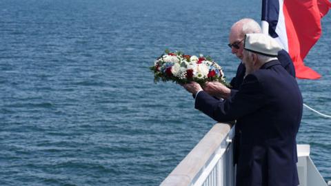 D-Day veterans Harry Birdsall, 98, and Alec Penstone (front), 98, throw a wreath into the sea during the Spirit of Normandy Trust wreath-laying service just off the French coastline, to remember those who never made it to shore
